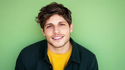 Portrait Of A Smiling Young Man Against Green Background