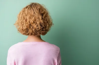 Back View Of A Woman With Curly Blonde Hair