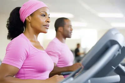 African American Couple Exercising on Treadmills at Gym