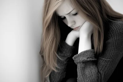 Sad Young Woman Resting Her Chin On Her Hands