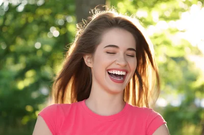 Young Woman Laughing Outdoors In Sunlight