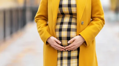 Pregnant Woman Wearing Yellow Coat And Plaid Dress