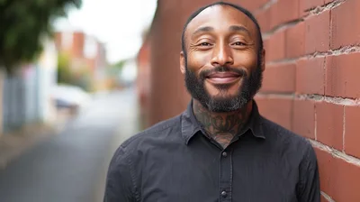 Portrait Of A Smiling Man With Neck Tattoos