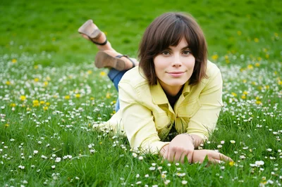 Young Woman Relaxing In A Meadow Of Daisies
