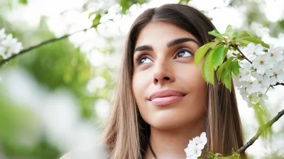 Young Woman Looking Up Amidst Blooming Cherry Blossoms