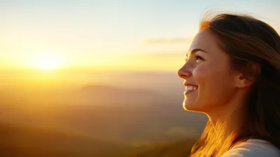 Young Woman Smiling At Sunset Over Mountain Landscape
