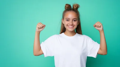 Happy Young Woman Flexing Muscles Against Teal Background