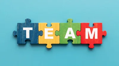 Four Colorful Puzzle Pieces Forming The Word Team