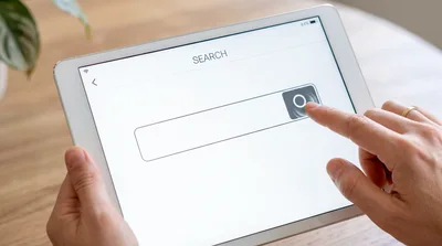 Person Using Search Bar on Tablet Computer