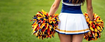 Cheerleader Holding Pom Poms On A Sports Field