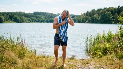 Mature Man Drying Hair With Towel By The Lake
