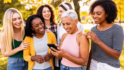 Diverse Group of Women Looking at Smartphone Outdoors