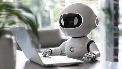 Small White Robot Typing on a Laptop