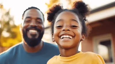 Happy African American Father And Daughter Smiling Outdoors