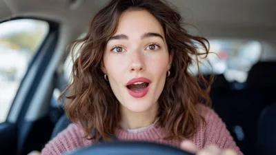Surprised Young Woman Driving A Car