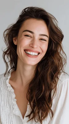 Portrait Of A Smiling Woman With Wavy Brown Hair