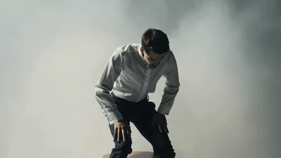 Man In White Shirt Standing Up From Stool