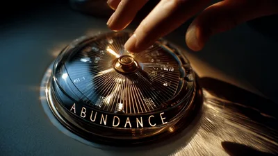 Hand Touching A Golden Compass Dial With Abundance Text