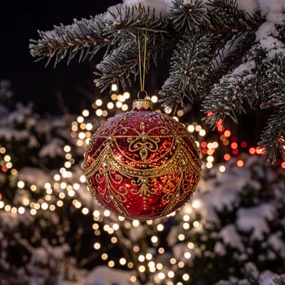 Red Christmas Ornament Hanging on Snowy Pine Branch