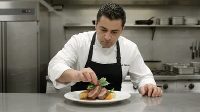 Professional Chef Plating A Gourmet Meat Dish