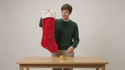 Person Holding Up A Red Christmas Stocking
