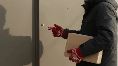 Delivery Person Ringing Doorbell With Package