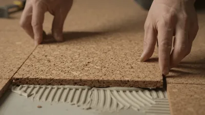 Worker Installing Cork Floor Tile With Adhesive