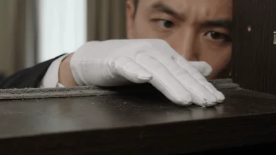 Professional Inspector Checking Furniture Surface For Dust