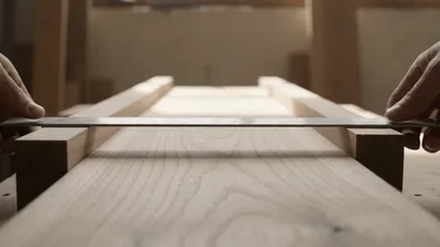 Carpenter Checking Wood Surface Flatness With Metal Ruler