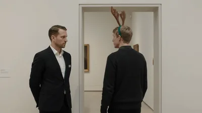 Museum Guard Greets Visitor Wearing Reindeer Antlers Headband