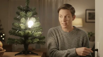Person Plugging In A Christmas Tree Light Bulb