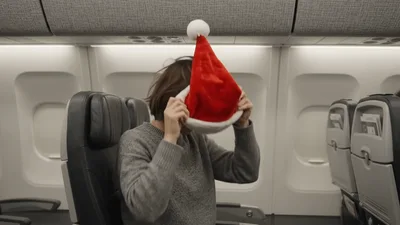 Woman Removing Santa Hat While Sitting On Airplane