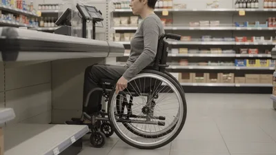 Woman In Wheelchair Waiting At Grocery Store Checkout