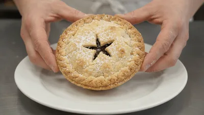 Hands Presenting A Freshly Baked Mince Pie