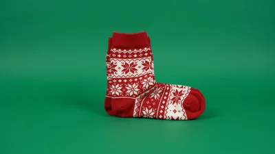 Red Christmas Sock Sliding Across Green Background