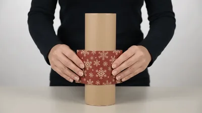 Person Sliding Decorative Paper Sleeve Down Cardboard Tube