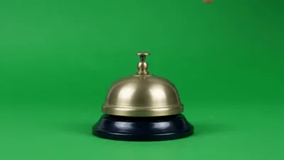 Hand Pressing A Brass Service Bell On Green Screen
