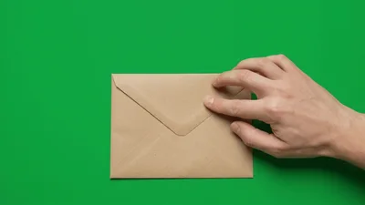 Hand Closing A Brown Paper Envelope On Green Screen
