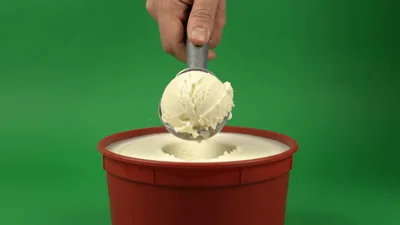 Hand Scooping Vanilla Ice Cream From Tub
