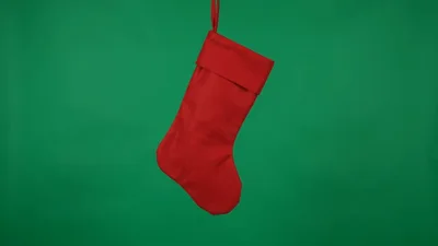 Red Christmas Stocking Hanging Against Green Screen Background