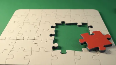 Red Puzzle Piece Sliding Out Of White Puzzle