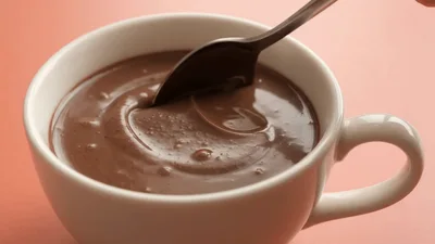 Spoon Stirring Thick Creamy Chocolate In A White Cup