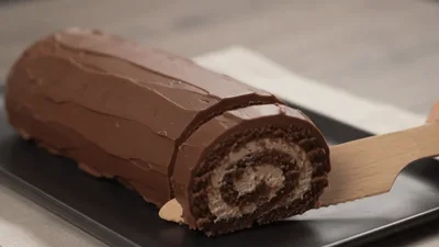 Wooden Knife Slicing A Chocolate Swiss Roll Cake