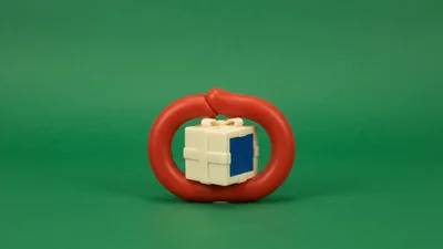Red Sausage Ring Enclosing A Small Gift Box