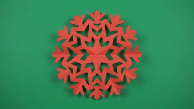 Red Paper Snowflake Unfolding On Green Background