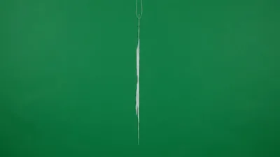 White Paper Snowflake Ornament Rotating Against Green Background