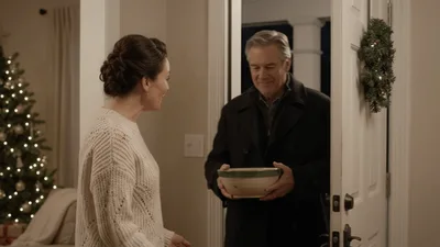 Woman Welcoming Older Man Into Her Home For Christmas