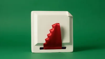 Red Ribbon Emerging From A White Square Box