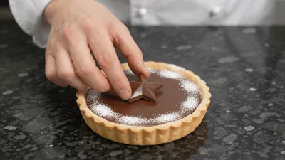 Pastry Chef Placing Chocolate Star On Tart