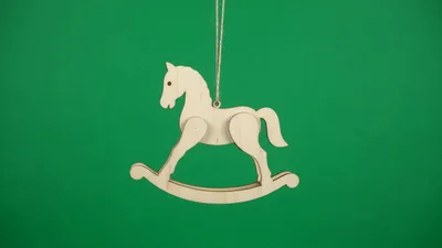 Wooden Rocking Horse Ornament Hanging Against Green Screen